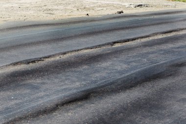 Bozuk yol çukurların ve nokta ile kıyılmış asfalt zarar görmüş. Çok kötü asfalt yol ile büyük trenche. Korkunç teknoloji yol asfalt üretim. Yumuşak asfalt ısı erir