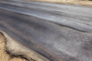 Bozuk yol çukurların ve nokta ile kıyılmış asfalt zarar görmüş. Çok kötü asfalt yol ile büyük trenche. Korkunç teknoloji yol asfalt üretim. Yumuşak asfalt ısı erir