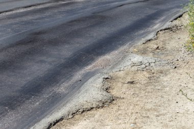 Bozuk yol çukurların ve nokta ile kıyılmış asfalt zarar görmüş. Çok kötü asfalt yol ile büyük trenche. Korkunç teknoloji yol asfalt üretim. Yumuşak asfalt ısı erir