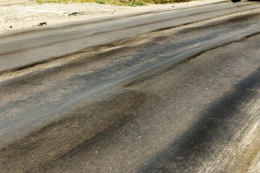 Bozuk yol çukurların ve nokta ile kıyılmış asfalt zarar görmüş. Çok kötü asfalt yol ile büyük trenche. Korkunç teknoloji yol asfalt üretim. Yumuşak asfalt ısı erir