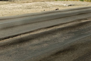 Bozuk yol çukurların ve nokta ile kıyılmış asfalt zarar görmüş. Çok kötü asfalt yol ile büyük trenche. Korkunç teknoloji yol asfalt üretim. Yumuşak asfalt ısı erir