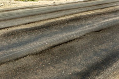 Bozuk yol çukurların ve nokta ile kıyılmış asfalt zarar görmüş. Çok kötü asfalt yol ile büyük trenche. Korkunç teknoloji yol asfalt üretim. Yumuşak asfalt ısı erir