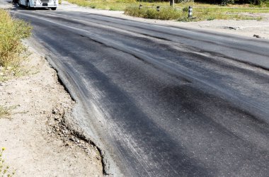 Bozuk yol çukurların ve nokta ile kıyılmış asfalt zarar görmüş. Çok kötü asfalt yol ile büyük trenche. Korkunç teknoloji yol asfalt üretim. Yumuşak asfalt ısı erir