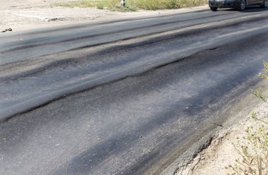 Bozuk yol çukurların ve nokta ile kıyılmış asfalt zarar görmüş. Çok kötü asfalt yol ile büyük trenche. Korkunç teknoloji yol asfalt üretim. Yumuşak asfalt ısı erir
