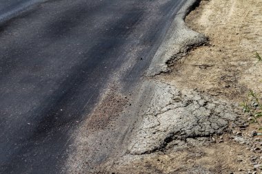 Bozuk yol çukurların ve nokta ile kıyılmış asfalt zarar görmüş. Çok kötü asfalt yol ile büyük trenche. Korkunç teknoloji yol asfalt üretim. Yumuşak asfalt ısı erir