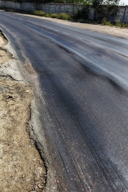 Bozuk yol çukurların ve nokta ile kıyılmış asfalt zarar görmüş. Çok kötü asfalt yol ile büyük trenche. Korkunç teknoloji yol asfalt üretim. Yumuşak asfalt ısı erir