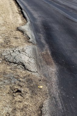 Bozuk yol çukurların ve nokta ile kıyılmış asfalt zarar görmüş. Çok kötü asfalt yol ile büyük trenche. Korkunç teknoloji yol asfalt üretim. Yumuşak asfalt ısı erir