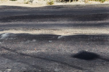Bozuk yol çukurların ve nokta ile kıyılmış asfalt zarar görmüş. Çok kötü asfalt yol ile büyük trenche. Korkunç teknoloji yol asfalt üretim. Yumuşak asfalt ısı erir