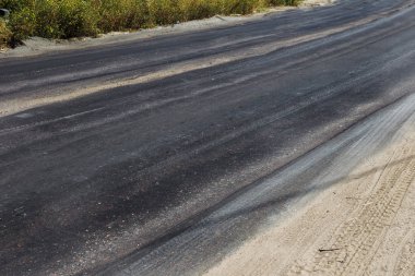 Bozuk yol çukurların ve nokta ile kıyılmış asfalt zarar görmüş. Çok kötü asfalt yol ile büyük trenche. Korkunç teknoloji yol asfalt üretim. Yumuşak asfalt ısı erir
