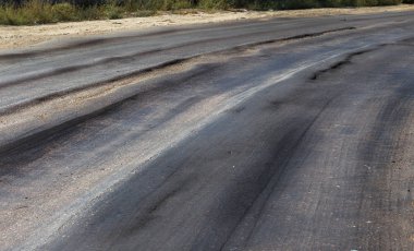 Bozuk yol çukurların ve nokta ile kıyılmış asfalt zarar görmüş. Çok kötü asfalt yol ile büyük trenche. Korkunç teknoloji yol asfalt üretim. Yumuşak asfalt ısı erir