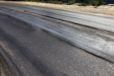 Bozuk yol çukurların ve nokta ile kıyılmış asfalt zarar görmüş. Çok kötü asfalt yol ile büyük trenche. Korkunç teknoloji yol asfalt üretim. Yumuşak asfalt ısı erir