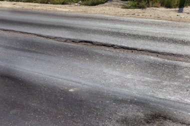 Bozuk yol çukurların ve nokta ile kıyılmış asfalt zarar görmüş. Çok kötü asfalt yol ile büyük trenche. Korkunç teknoloji yol asfalt üretim. Yumuşak asfalt ısı erir