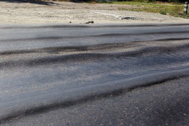 Bozuk yol çukurların ve nokta ile kıyılmış asfalt zarar görmüş. Çok kötü asfalt yol ile büyük trenche. Korkunç teknoloji yol asfalt üretim. Yumuşak asfalt ısı erir