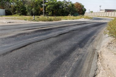 Bozuk yol çukurların ve nokta ile kıyılmış asfalt zarar görmüş. Çok kötü asfalt yol ile büyük trenche. Korkunç teknoloji yol asfalt üretim. Yumuşak asfalt ısı erir