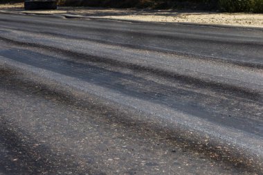 Bozuk yol çukurların ve nokta ile kıyılmış asfalt zarar görmüş. Çok kötü asfalt yol ile büyük trenche. Korkunç teknoloji yol asfalt üretim. Yumuşak asfalt ısı erir