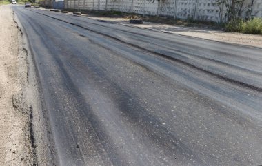 Bozuk yol çukurların ve nokta ile kıyılmış asfalt zarar görmüş. Çok kötü asfalt yol ile büyük trenche. Korkunç teknoloji yol asfalt üretim. Yumuşak asfalt ısı erir
