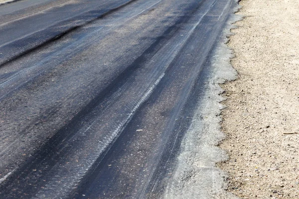 Bozuk yol çukurların ve nokta ile kıyılmış asfalt zarar görmüş. Çok kötü asfalt yol ile büyük trenche. Korkunç teknoloji yol asfalt üretim. Yumuşak asfalt ısı erir
