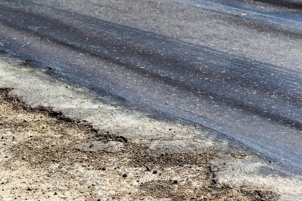 Bozuk yol çukurların ve nokta ile kıyılmış asfalt zarar görmüş. Çok kötü asfalt yol ile büyük trenche. Korkunç teknoloji yol asfalt üretim. Yumuşak asfalt ısı erir