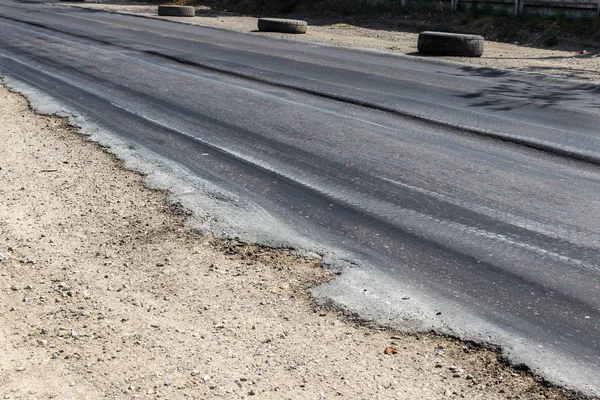 Bozuk yol çukurların ve nokta ile kıyılmış asfalt zarar görmüş. Çok kötü asfalt yol ile büyük trenche. Korkunç teknoloji yol asfalt üretim. Yumuşak asfalt ısı erir