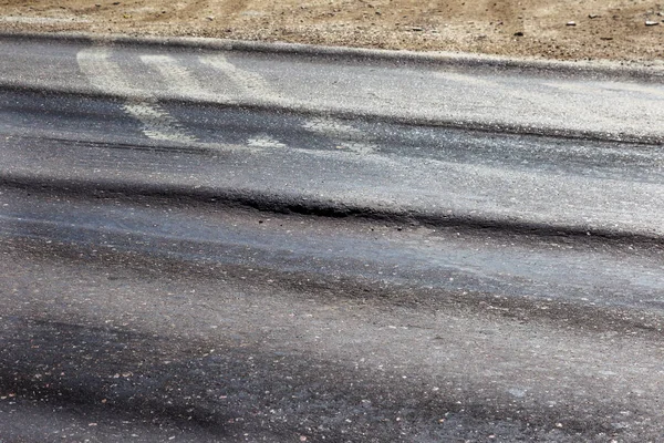 Bozuk yol çukurların ve nokta ile kıyılmış asfalt zarar görmüş. Çok kötü asfalt yol ile büyük trenche. Korkunç teknoloji yol asfalt üretim. Yumuşak asfalt ısı erir