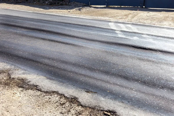Bozuk yol çukurların ve nokta ile kıyılmış asfalt zarar görmüş. Çok kötü asfalt yol ile büyük trenche. Korkunç teknoloji yol asfalt üretim. Yumuşak asfalt ısı erir