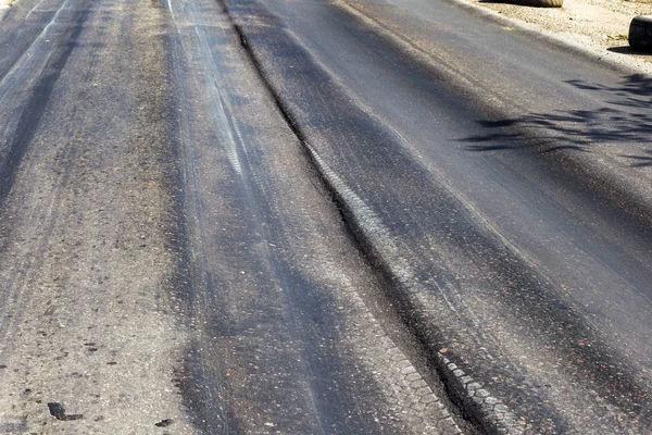 Bozuk yol çukurların ve nokta ile kıyılmış asfalt zarar görmüş. Çok kötü asfalt yol ile büyük trenche. Korkunç teknoloji yol asfalt üretim. Yumuşak asfalt ısı erir