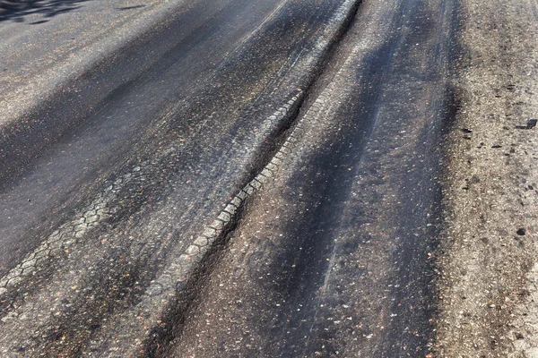 Bozuk yol çukurların ve nokta ile kıyılmış asfalt zarar görmüş. Çok kötü asfalt yol ile büyük trenche. Korkunç teknoloji yol asfalt üretim. Yumuşak asfalt ısı erir