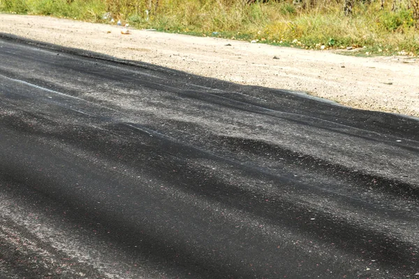 Bozuk yol çukurların ve nokta ile kıyılmış asfalt zarar görmüş. Çok kötü asfalt yol ile büyük trenche. Korkunç teknoloji yol asfalt üretim. Yumuşak asfalt ısı erir