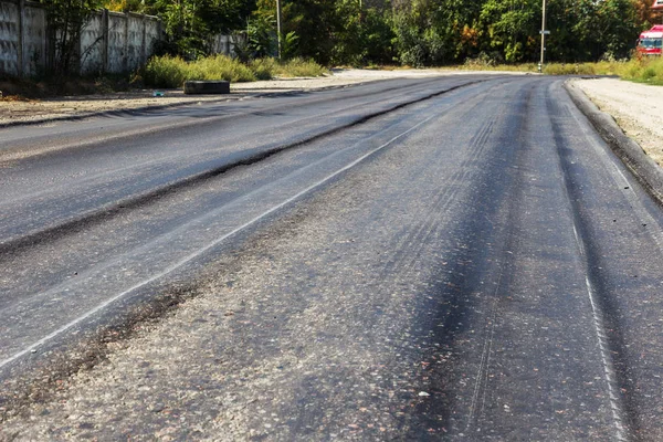 Bozuk yol çukurların ve nokta ile kıyılmış asfalt zarar görmüş. Çok kötü asfalt yol ile büyük trenche. Korkunç teknoloji yol asfalt üretim. Yumuşak asfalt ısı erir