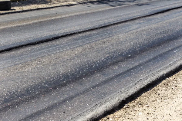 Bozuk yol çukurların ve nokta ile kıyılmış asfalt zarar görmüş. Çok kötü asfalt yol ile büyük trenche. Korkunç teknoloji yol asfalt üretim. Yumuşak asfalt ısı erir