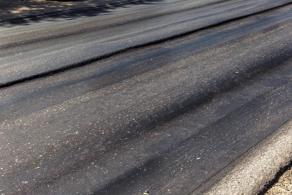 破損した道路には 甌穴とスポットでアスファルトをみじん切りが破損しています 大規模な Trenche と非常に悪いアスファルトの道路 アスファルト道路の建設生産の恐るべき技術 軟質アスファルトを溶かす熱から — ストック写真