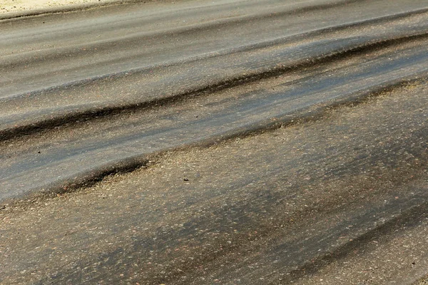 Bozuk yol çukurların ve nokta ile kıyılmış asfalt zarar görmüş. Çok kötü asfalt yol ile büyük trenche. Korkunç teknoloji yol asfalt üretim. Yumuşak asfalt ısı erir