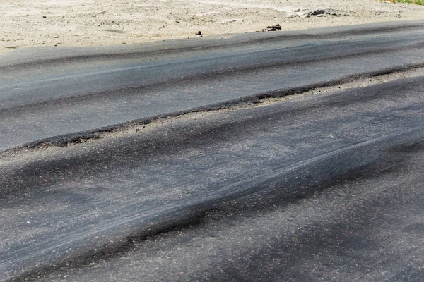 Bozuk yol çukurların ve nokta ile kıyılmış asfalt zarar görmüş. Çok kötü asfalt yol ile büyük trenche. Korkunç teknoloji yol asfalt üretim. Yumuşak asfalt ısı erir