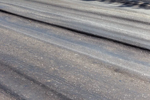 Bozuk yol çukurların ve nokta ile kıyılmış asfalt zarar görmüş. Çok kötü asfalt yol ile büyük trenche. Korkunç teknoloji yol asfalt üretim. Yumuşak asfalt ısı erir