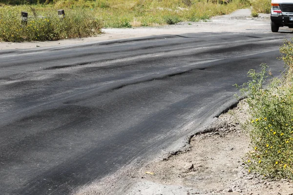 Bozuk yol çukurların ve nokta ile kıyılmış asfalt zarar görmüş. Çok kötü asfalt yol ile büyük trenche. Korkunç teknoloji yol asfalt üretim. Yumuşak asfalt ısı erir