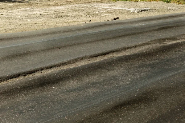 Bozuk yol çukurların ve nokta ile kıyılmış asfalt zarar görmüş. Çok kötü asfalt yol ile büyük trenche. Korkunç teknoloji yol asfalt üretim. Yumuşak asfalt ısı erir