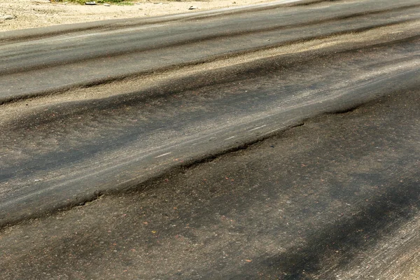 Bozuk yol çukurların ve nokta ile kıyılmış asfalt zarar görmüş. Çok kötü asfalt yol ile büyük trenche. Korkunç teknoloji yol asfalt üretim. Yumuşak asfalt ısı erir