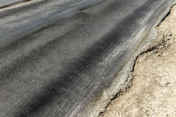 Bozuk yol çukurların ve nokta ile kıyılmış asfalt zarar görmüş. Çok kötü asfalt yol ile büyük trenche. Korkunç teknoloji yol asfalt üretim. Yumuşak asfalt ısı erir