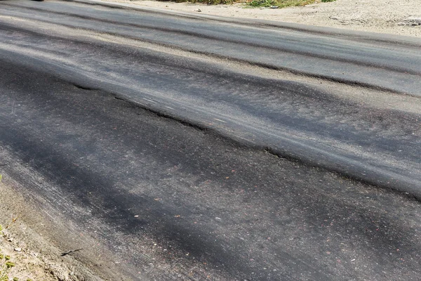 Bozuk yol çukurların ve nokta ile kıyılmış asfalt zarar görmüş. Çok kötü asfalt yol ile büyük trenche. Korkunç teknoloji yol asfalt üretim. Yumuşak asfalt ısı erir