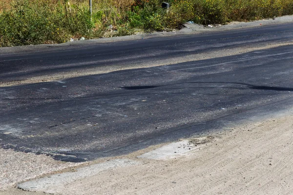 Bozuk yol çukurların ve nokta ile kıyılmış asfalt zarar görmüş. Çok kötü asfalt yol ile büyük trenche. Korkunç teknoloji yol asfalt üretim. Yumuşak asfalt ısı erir