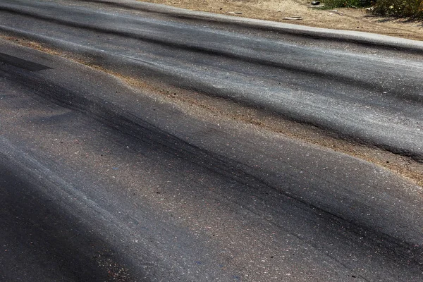 Bozuk yol çukurların ve nokta ile kıyılmış asfalt zarar görmüş. Çok kötü asfalt yol ile büyük trenche. Korkunç teknoloji yol asfalt üretim. Yumuşak asfalt ısı erir
