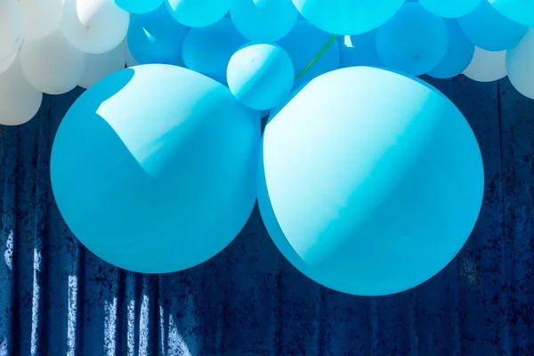 Air balloons background, big bunch of helium balloons, happy birthday, surprise for holiday, decoration. Festive background of blue and white air balloons of different sizes on sky background.