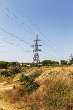 Güç hatları. Elektrik Dağıtım İstasyonu. Yüksek gerilim enerji iletim kulesi ile yüksek gerilim öğleden sonra şehir dışında bozkır içinde teller