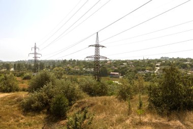 Güç hatları. Elektrik Dağıtım İstasyonu. Yüksek gerilim enerji iletim kulesi ile yüksek gerilim öğleden sonra şehir dışında bozkır içinde teller