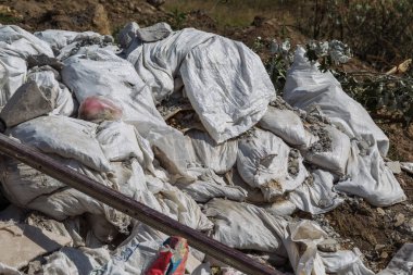 İnsanlar tarafından çevre kirliliği. Çorak içinde yasadışı çöp dökümü. Torbalarda bir çöplükte ev çöp yığını. Atık büyük bir yığın çöp Dağı'na uzanır
