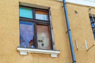 Binanın eski pencere kırılmış. Zavallı çeyrek. Kırık cam penceresinde. Kırık pencereyi yağmur ve rüzgar bir tahta kaplıdır. Daire soyguncular suç olayı