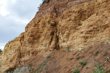 Karadeniz kıyısındaki heyelan bölgesi. Deniz taşı kabuğu. Yağmur mevsiminde doğal afetler bölgesi. Büyük toprak kütleleri tepenin yamacında kayıp evleri yok ediyor. Heyelan - yaşam tehdidi