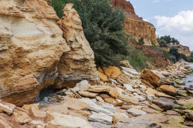 Karadeniz kıyısındaki heyelan bölgesi. Deniz taşı kabuğu. Yağmur mevsiminde doğal afetler bölgesi. Büyük toprak kütleleri tepenin yamacında kayıp evleri yok ediyor. Heyelan - yaşam tehdidi