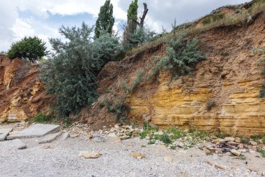 Karadeniz kıyısındaki heyelan bölgesi. Deniz taşı kabuğu. Yağmur mevsiminde doğal afetler bölgesi. Büyük toprak kütleleri tepenin yamacında kayıp evleri yok ediyor. Heyelan - yaşam tehdidi