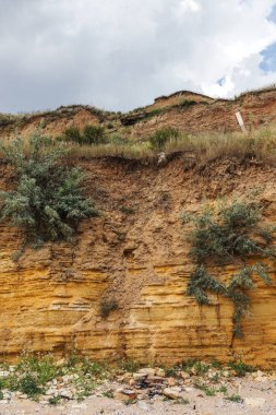 Karadeniz kıyısındaki heyelan bölgesi. Deniz taşı kabuğu. Yağmur mevsiminde doğal afetler bölgesi. Büyük toprak kütleleri tepenin yamacında kayıp evleri yok ediyor. Heyelan - yaşam tehdidi